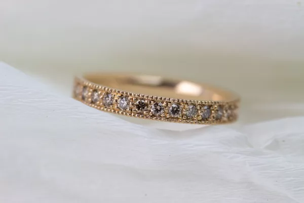 Einzigartiger Ehering aus Roségold. Der Damenring ist ein wahres Kunstwerk im Vintage-Stil, dekoriert mit vielen funkelnden braunen Diamanten.