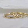 Zu sehen sind drei Ringe in Gelbgold: ein schlichter, abgerundeter Ehering mit glänzender Oberfläche, ein Beisteckring mit zwei ineinander verflochtenen Drähten und ein feiner Memoryring mit vielen kleinen Brillanten.