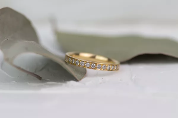 Elegantes Leuchten: Feiner Ring aus Roségold, matt und filigran gestaltet. Ein Memoryring mit funkelnden Brillanten, gehalten von zarten Kügelchen.