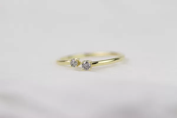 Gelbgold-Verlobungsring, handgefertigt und von zeitloser Eleganz. Sein modernes Design und die Krappenfassungen für die Salt und Pepper Diamanten machen diesen Ring zu einem einzigartigen Schmuckstück.