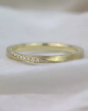 Eleganter Verlobungsring aus 585er Gelbgold, fein und mattiert, mit einer einzigartigen Form in Gestalt eines zarten Möbiusbandes, das von strahlenden Diamanten im Brillantschliff geschmückt ist.